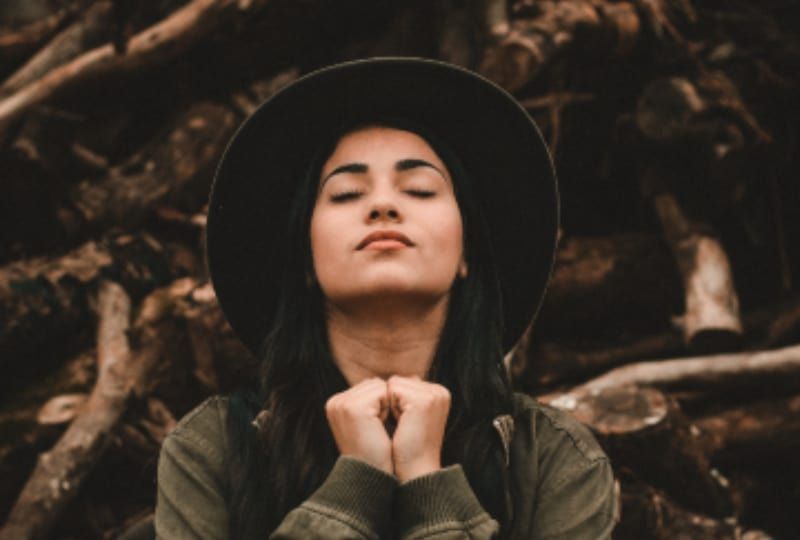 8 kjennetegn ved en uforglemmelig kvinne Ein Mädchen mit Hut betet in der Natur