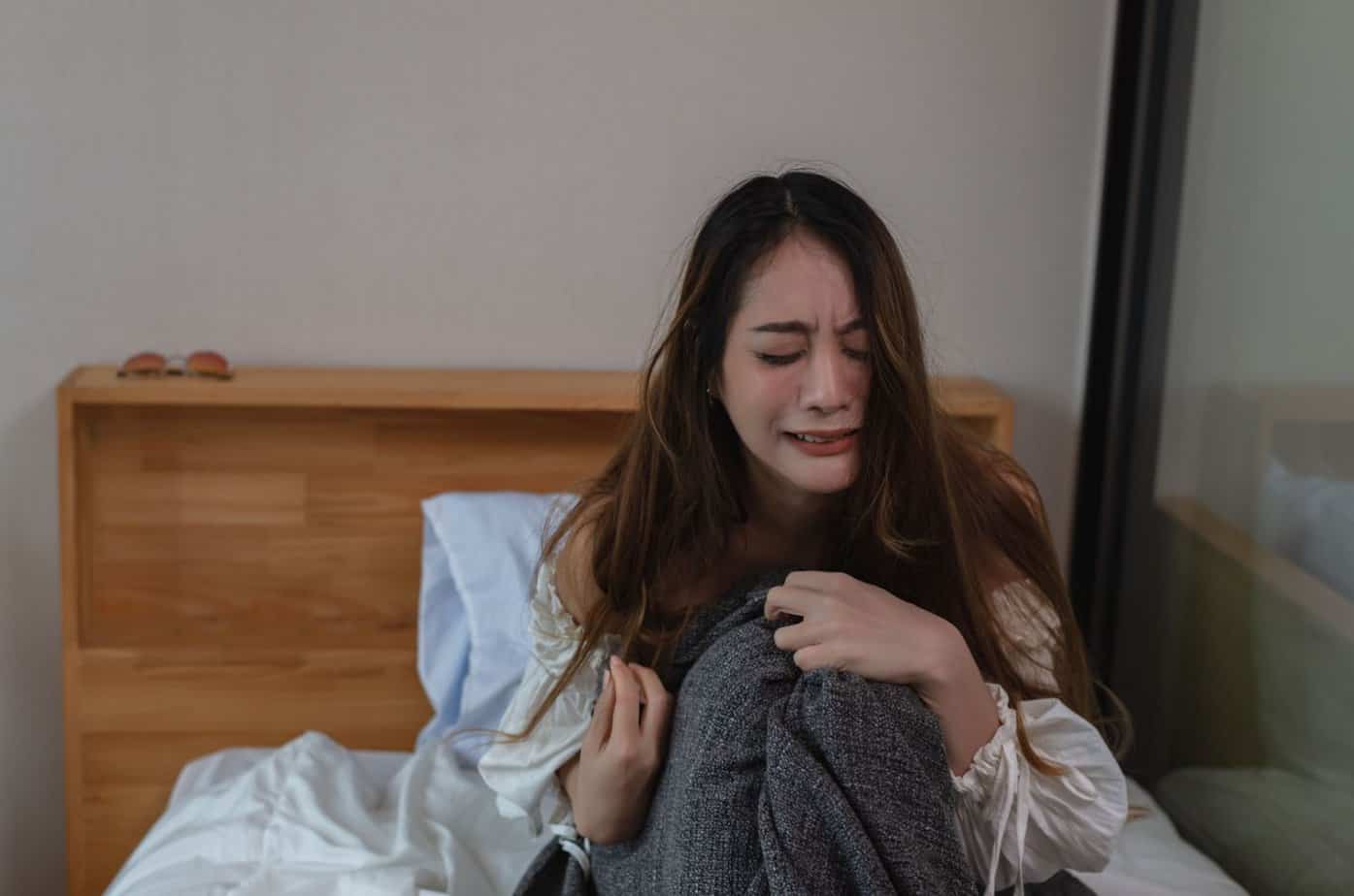 frau weint auf dem bett