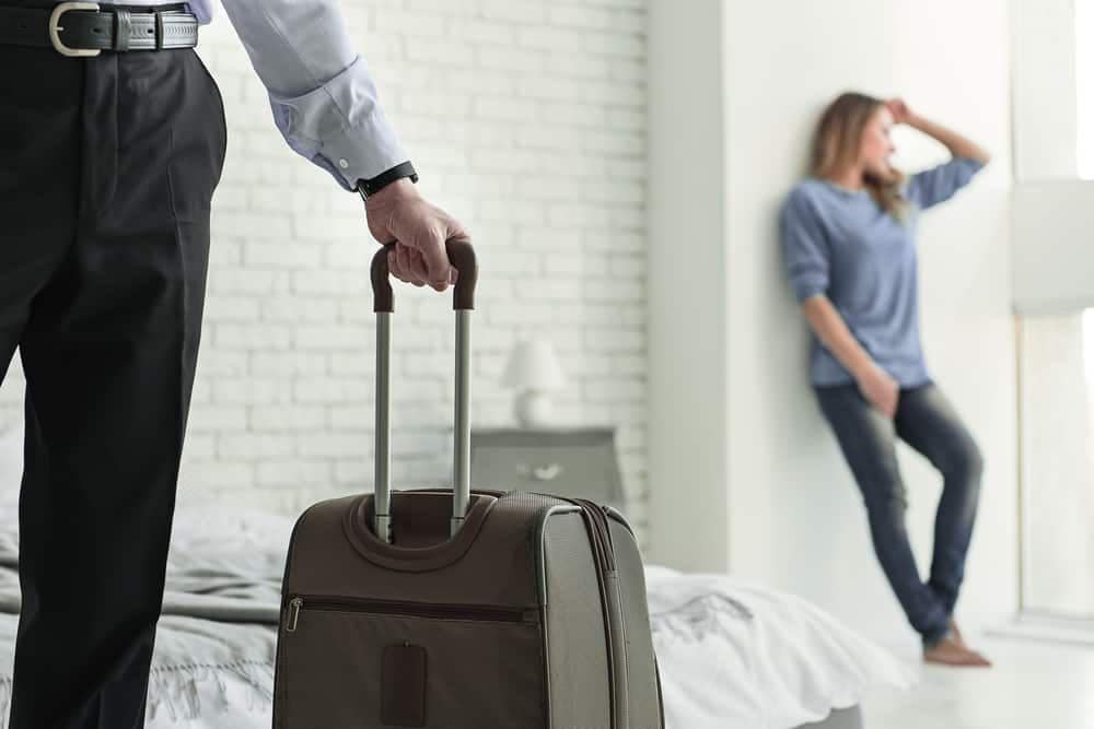 Ein Mann mit einem Koffer hinterlässt eine traurige Frau