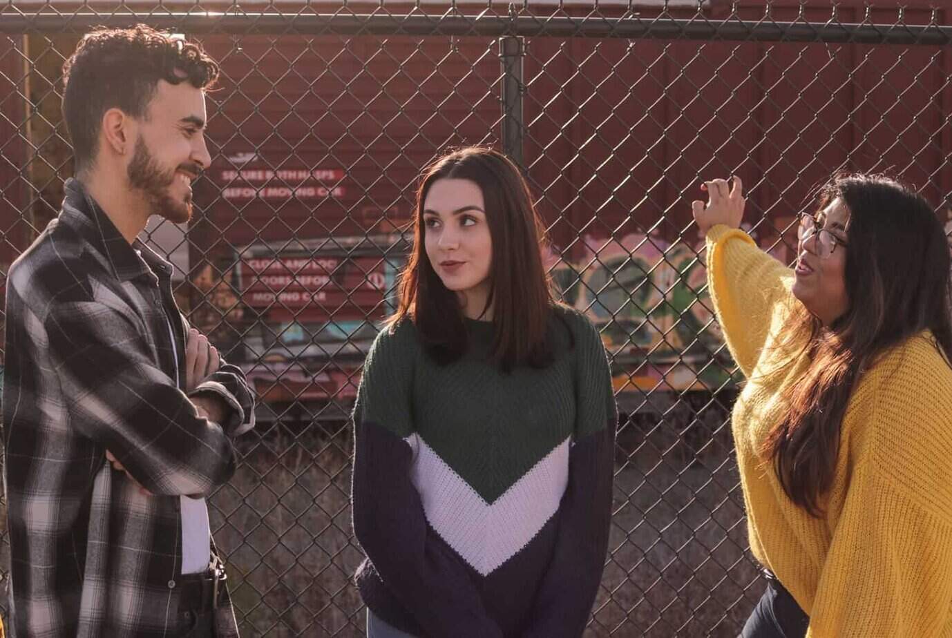 zwei Frauen, die lächelnden Mann betrachten, während sie nahe dem Zaun stehen