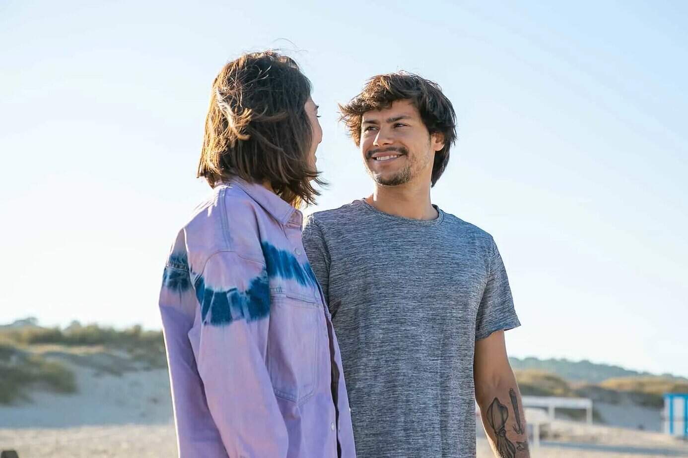 glücklicher Mann, der seine Freundin beim gemeinsamen Gehen am Strand ansieht