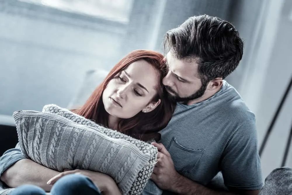 Jeg ville at du skulle kjempe for meg, men i stedet lot du meg gå eine traurige rothaarige Frau in den Armen ihres Mannes