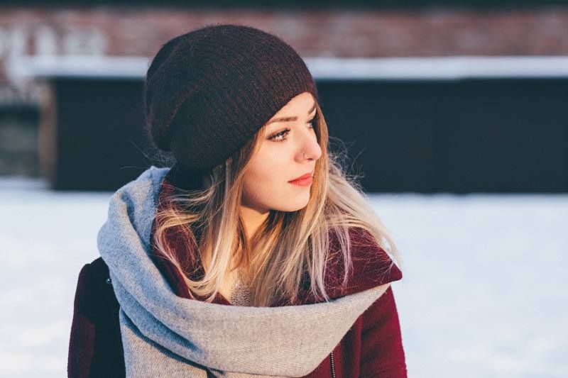 Jeg ville at du skulle kjempe for meg, men i stedet lot du meg gå Eine traurige Frau mit einer schwarzen Mütze steht im Schnee und schaut weg