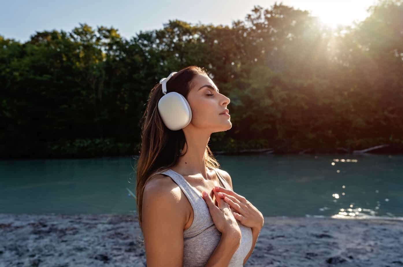 frau hoert musik in natur