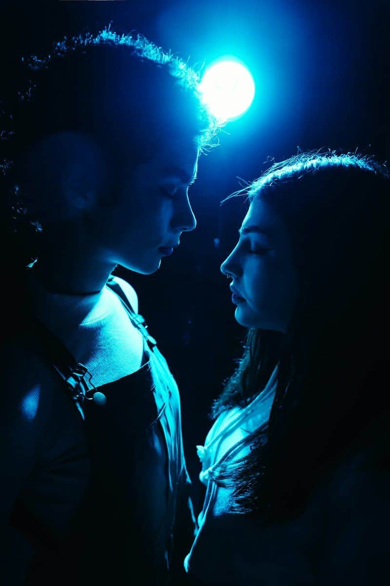 Two people gaze at each other under a blue light. photo ... Two people gaze at each other under a blue light. photo ...