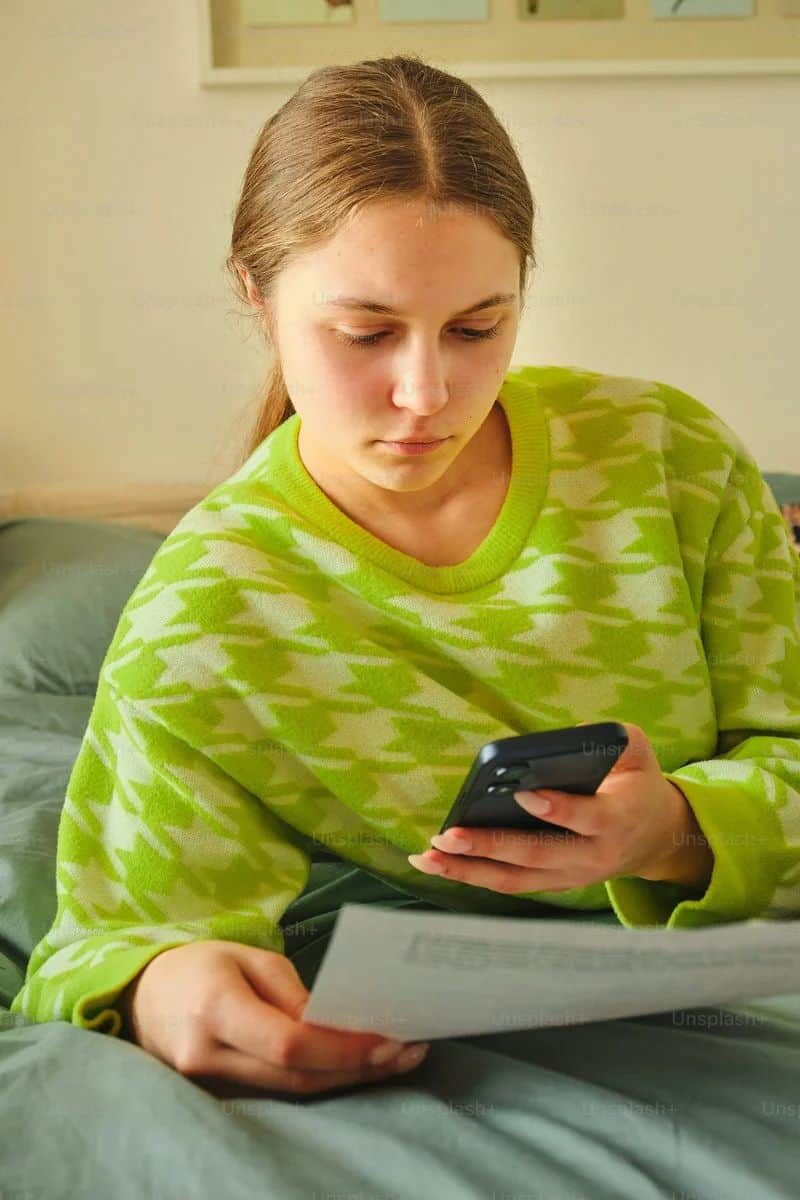 Young woman looking at phone while holding papers photo – Paper Image on Unsplash Young woman looking at phone while holding papers photo – Paper Image on Unsplash
