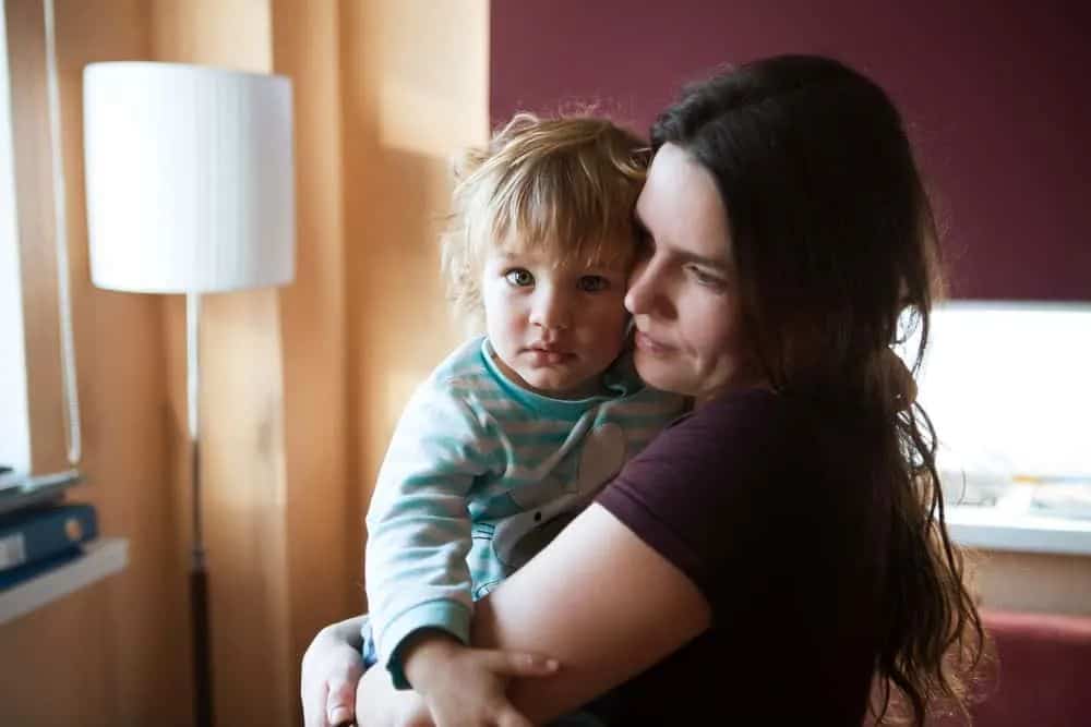 Til alle alenemødre der ute: Dere er de virkelige heltene Im Haus steht eine Mutter mit einem Kind im Arm