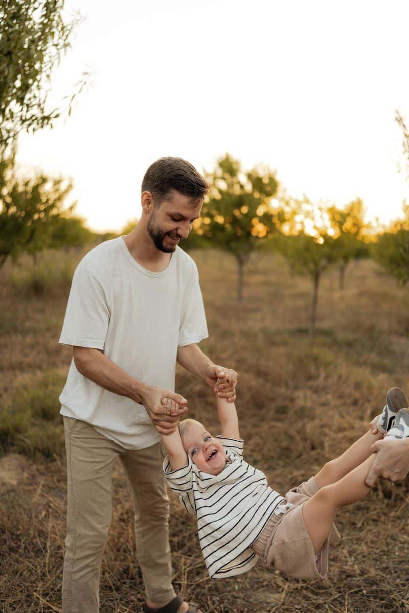 Father swinging happy child in an orchard photo – Free Green Image on  Unsplash