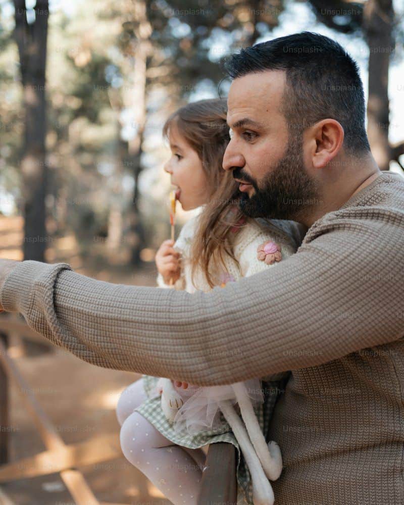 A man holding a little girl in his arms photo – Family Image ...