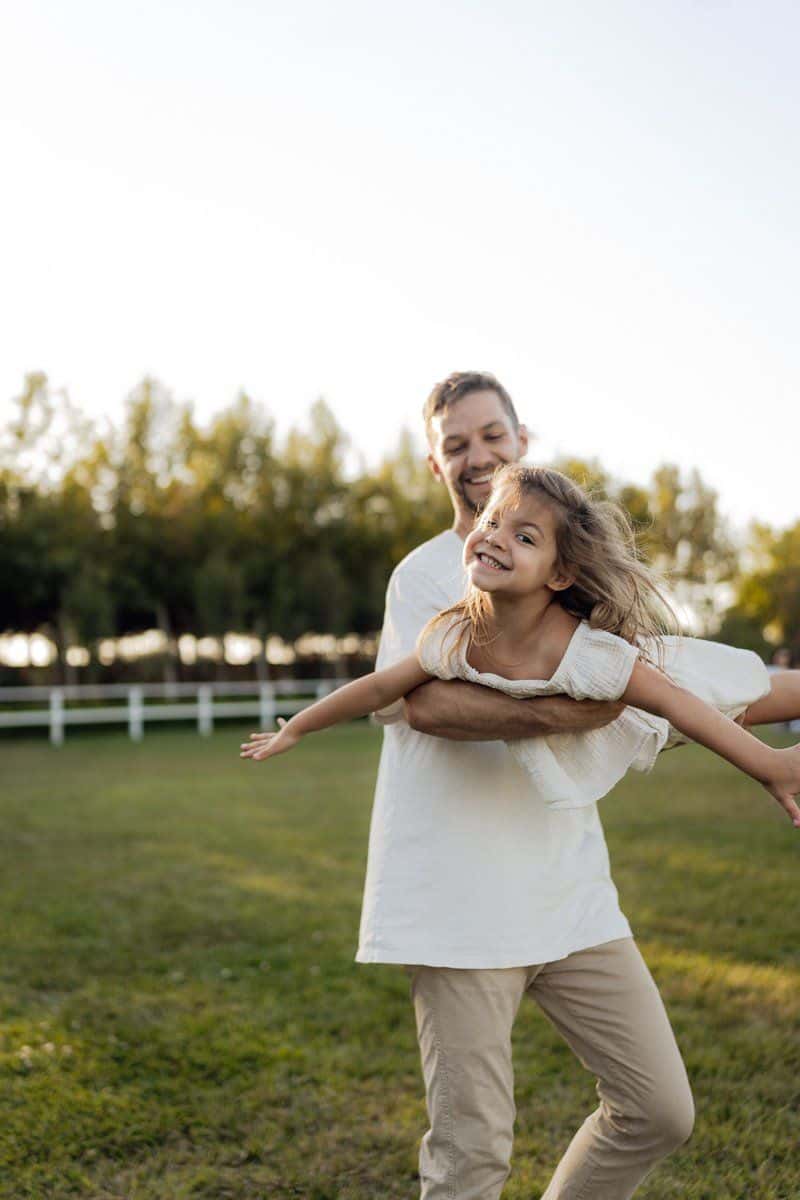 Father and Daughter Playing Joyfully Outdoors · Free Stock Photo