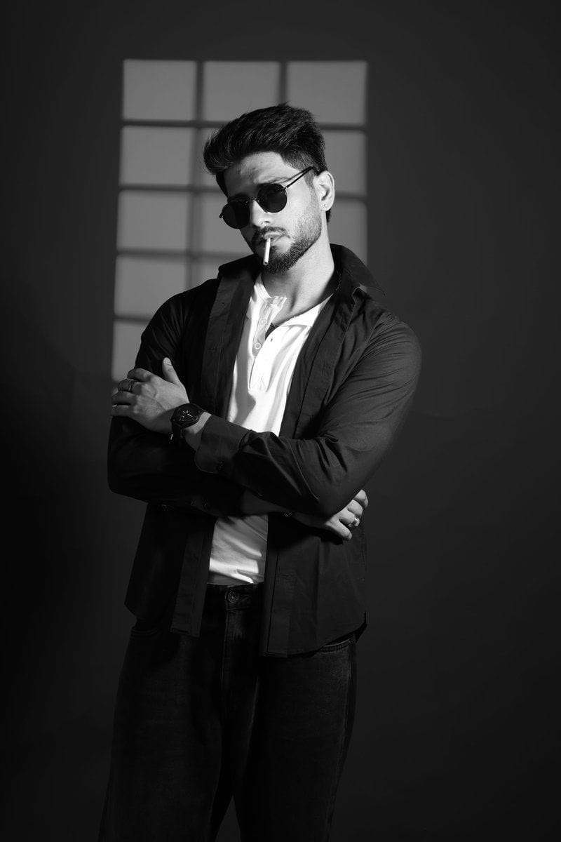 Stylish man with sunglasses and cigarette against a dark background. photo  – Free Watch Image on Unsplash