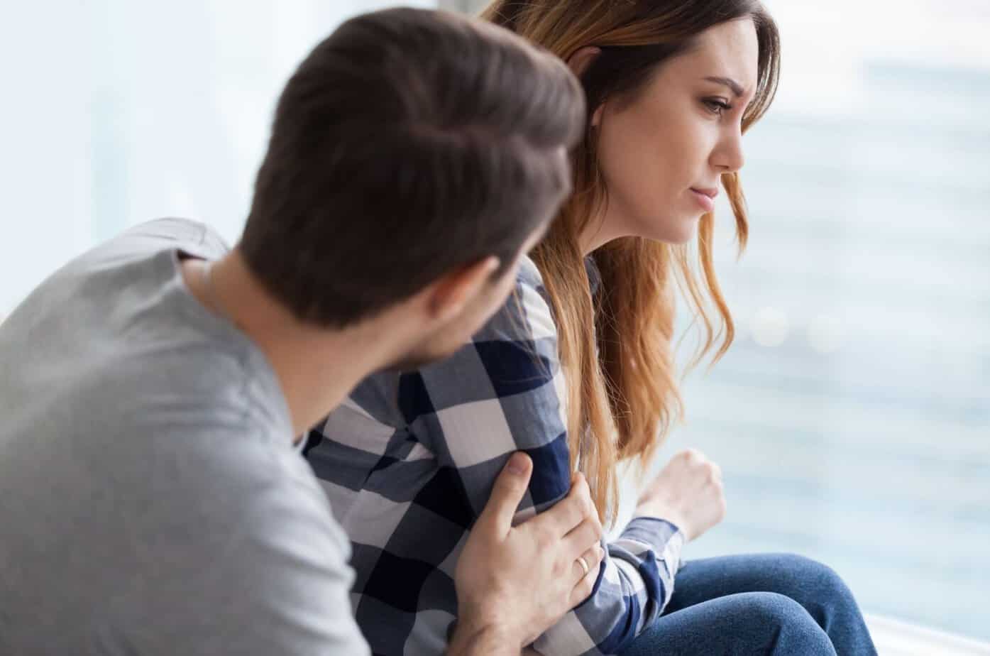 traurige frau sitzt neben mann