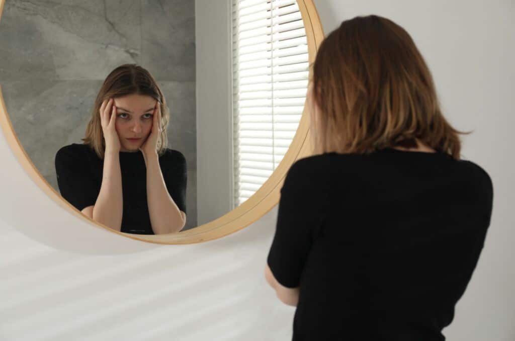 Er narsissister ofre for sin egen personlighet, eller er de gjerningspersoner som handler med fullt overlegg? depressive frau seteht vor einem spiegel