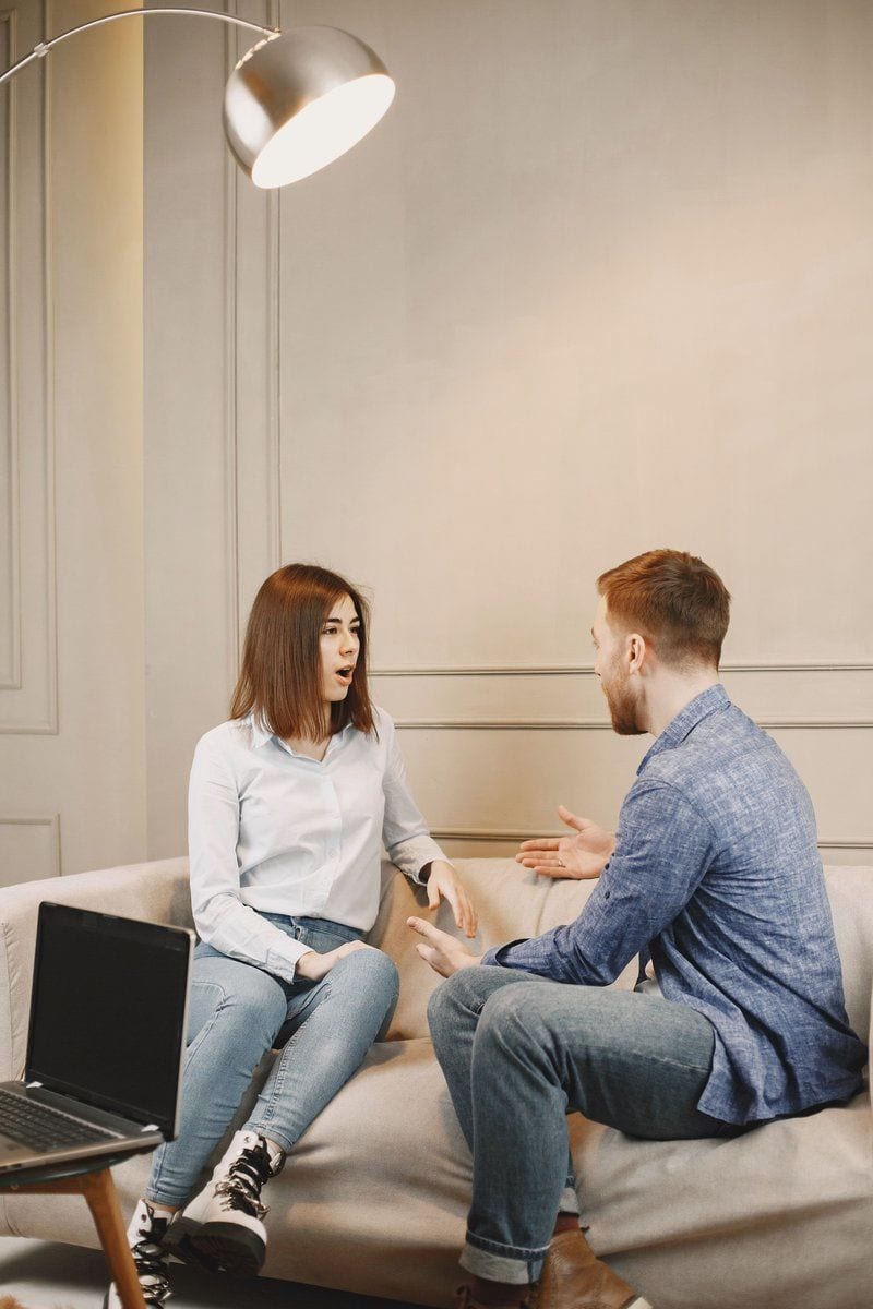 Close-Up Shot of a Man and a Woman Talking while Sitting on a Couch · Free  Stock Photo