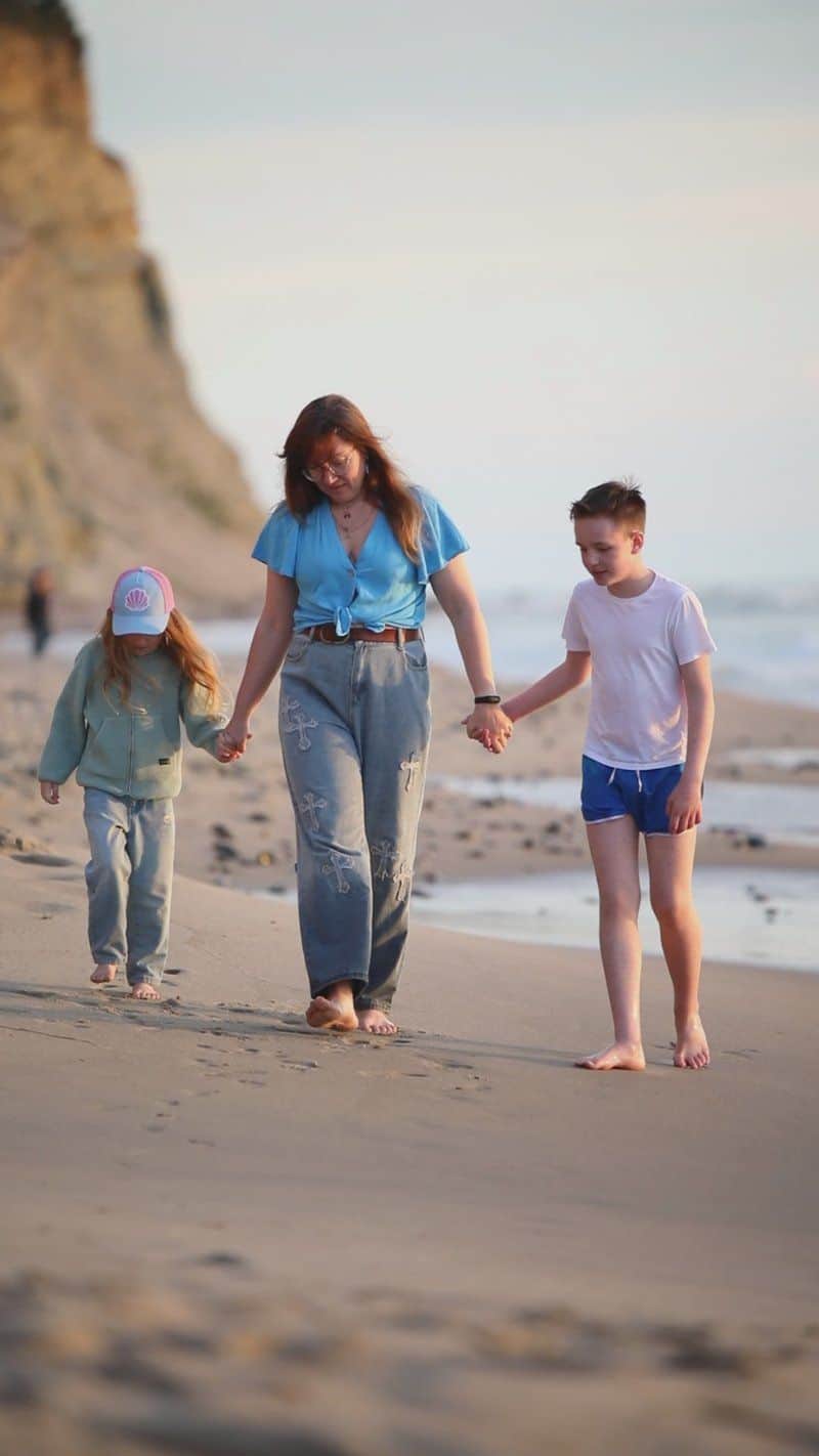 Family Walks Along Scenic Beach at Sunset Family Walks Along Scenic Beach at Sunset
