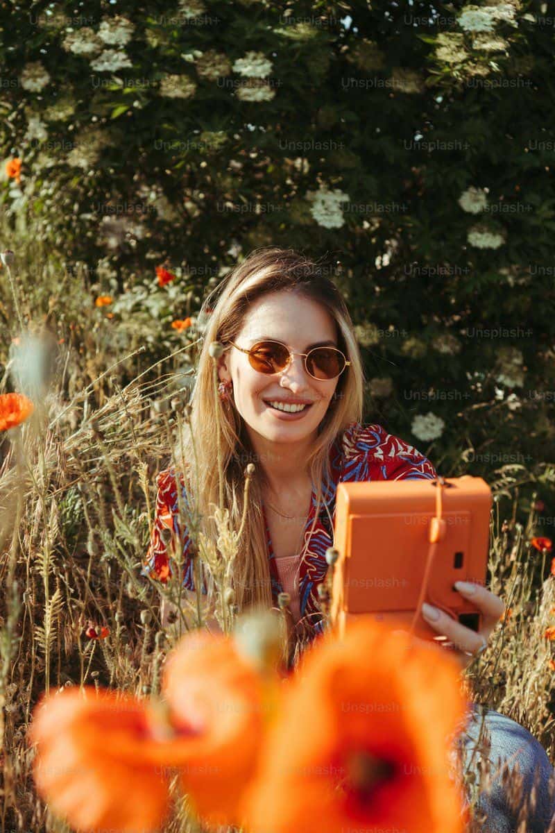 A woman sitting in a field with an orange tablet photo ... A woman sitting in a field with an orange tablet photo ...