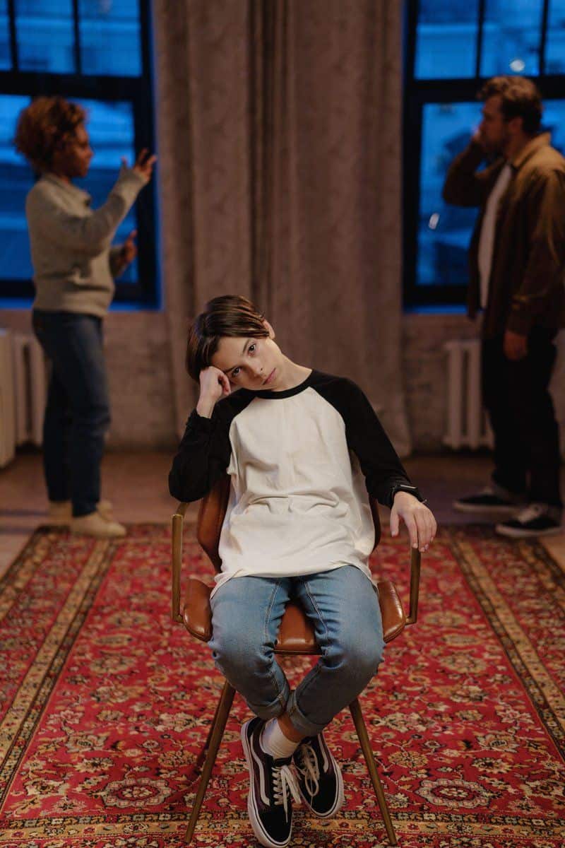 A Boy Sitting on a Chair with Quarreling Parents Behind ... A Boy Sitting on a Chair with Quarreling Parents Behind ...