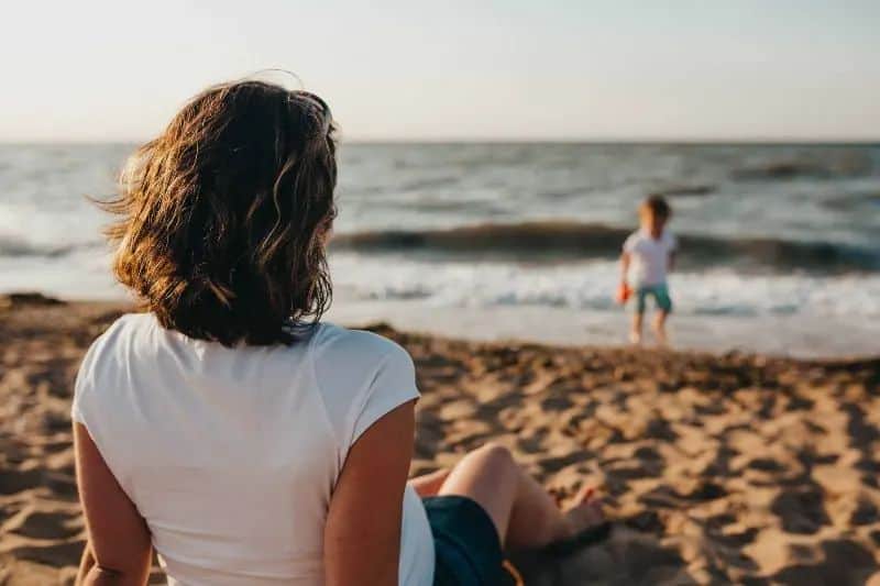 Jeg vil heller forbli singel enn å kaste bort livet mitt på en umoden idiot eine Frau, die ein Kind am Strand beobachtet(1)