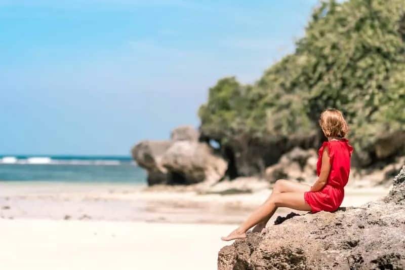 Jeg vil heller forbli singel enn å kaste bort livet mitt på en umoden idiot ein Mädchen beobachtet den Strand und sitzt auf einem Felsen(1)