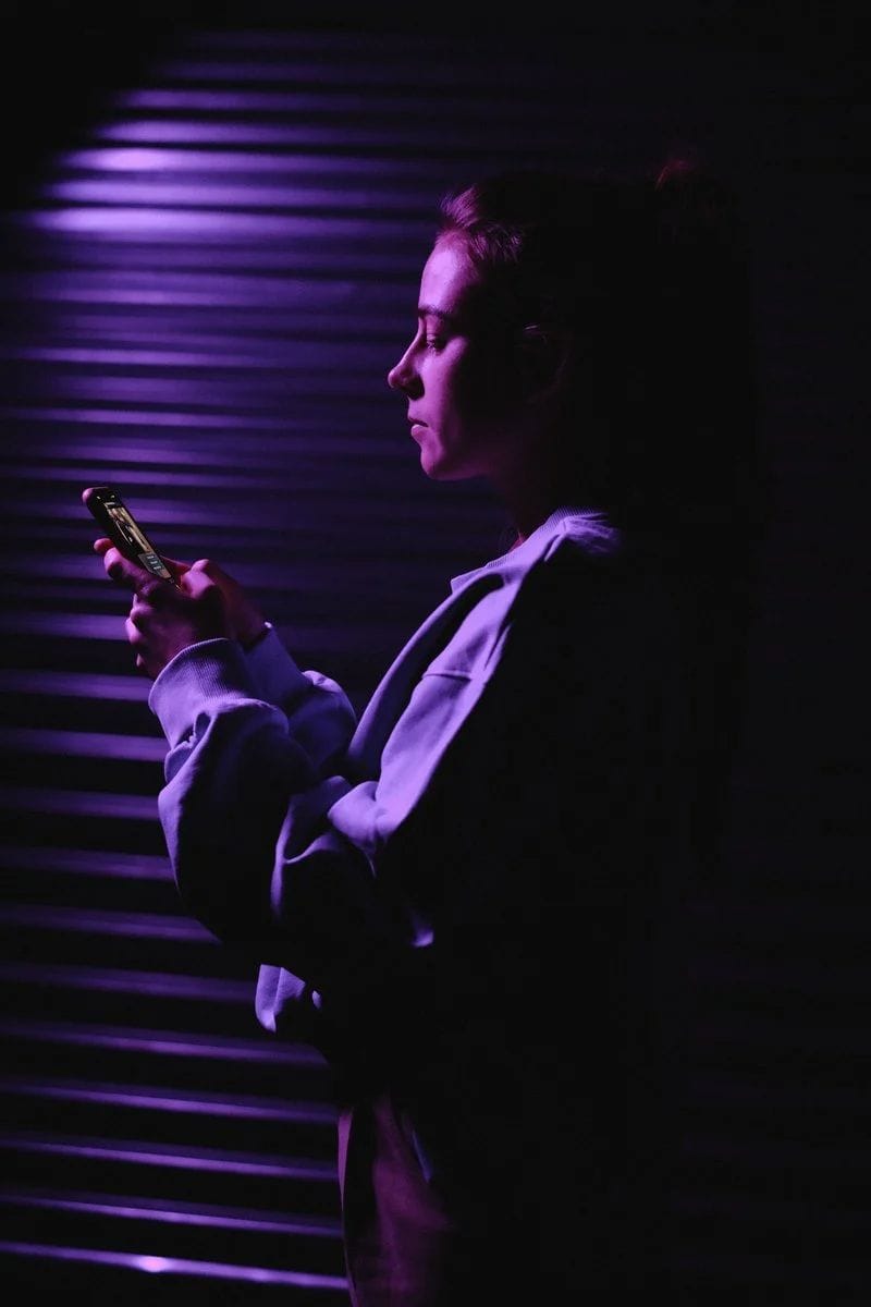 Woman in Sweater Holding Smartphone Illuminated in Purple Light · Free Stock Photo Woman in Sweater Holding Smartphone Illuminated in Purple Light · Free Stock Photo